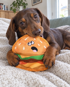 Teckel qui câline la peluche burger