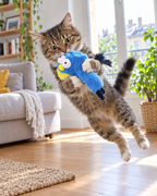 Chat tigré sautant sur l'oiseau en peluche