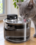 Chat gris buvant l'eau qui coule sur le plateau inox